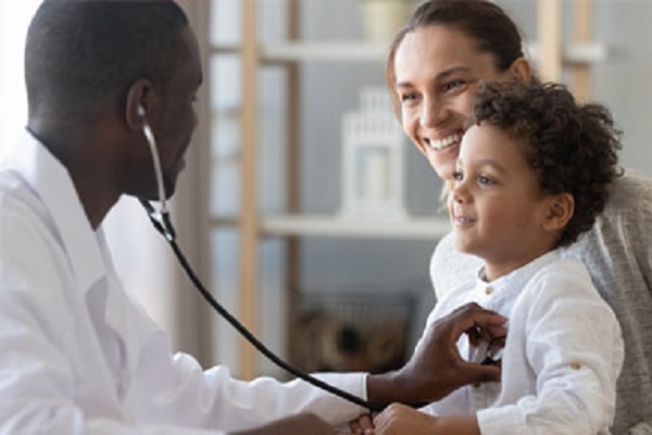 Doctor holding stethoscope to childs chest whilst child sits on mothers lap